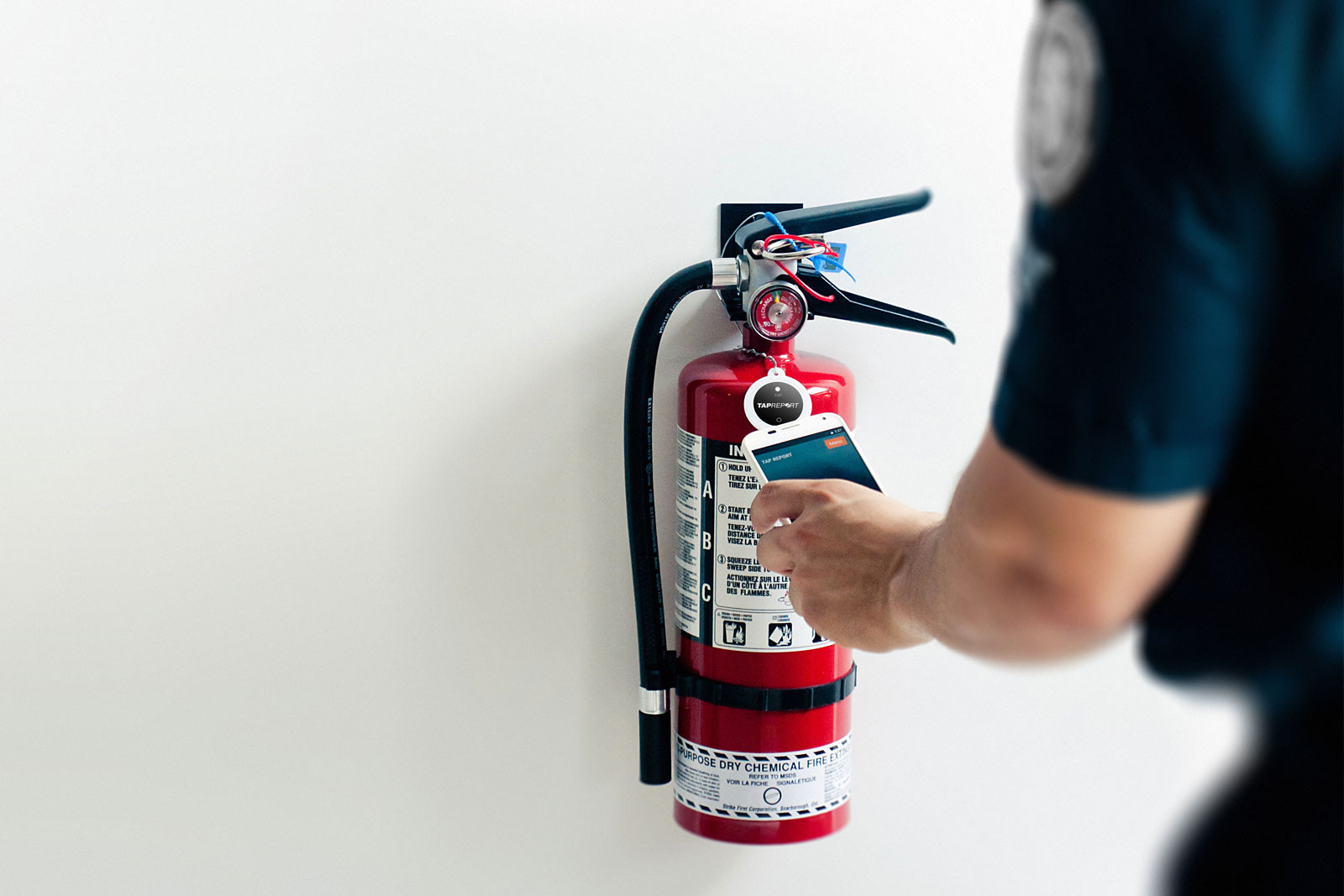 inspector tapping a smart tag on a fire extinguisher